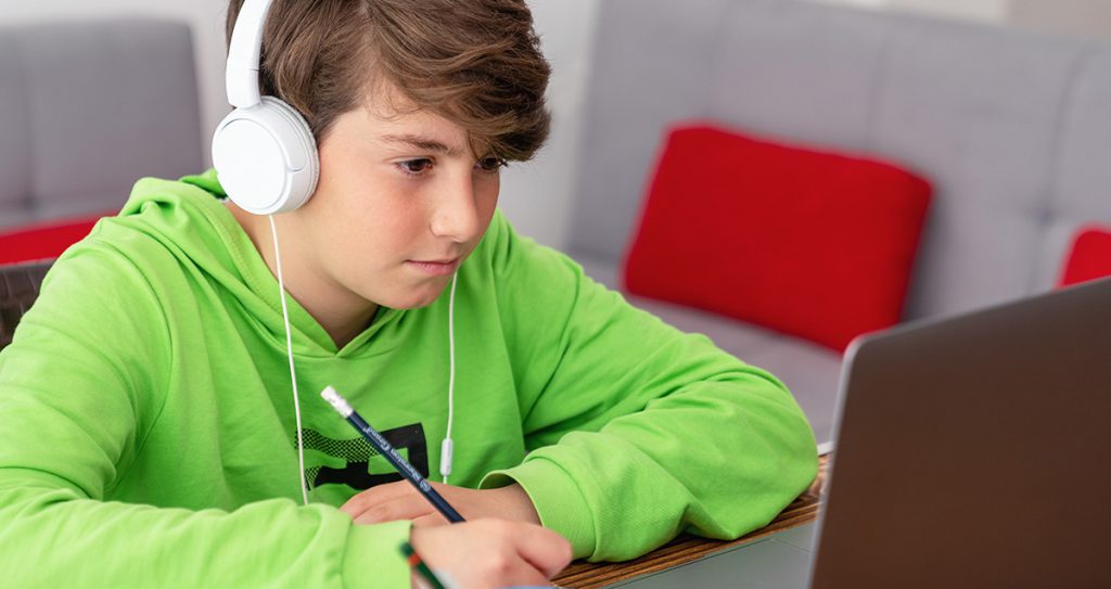 teenage boy working on a laptop